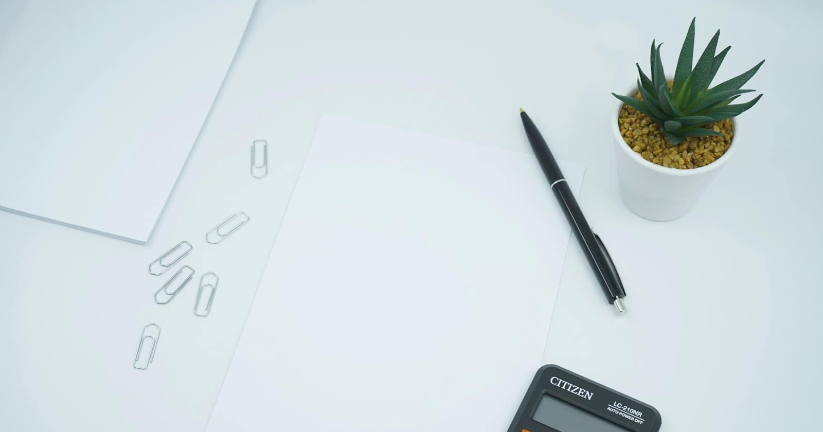 A calculator and financial notes on a desk