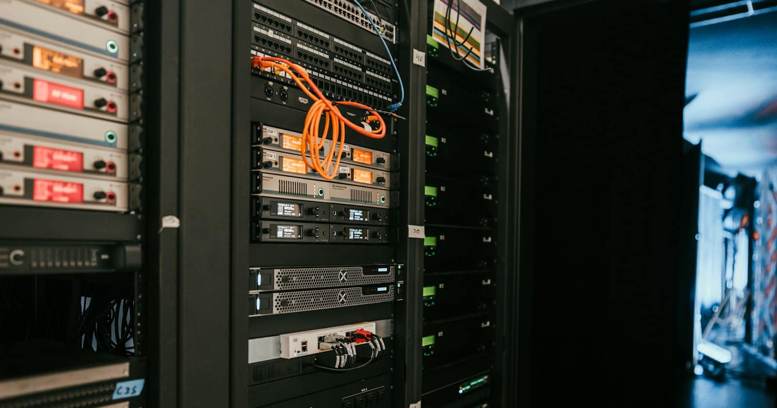 Rows of illuminated server racks running down a data centre aisle