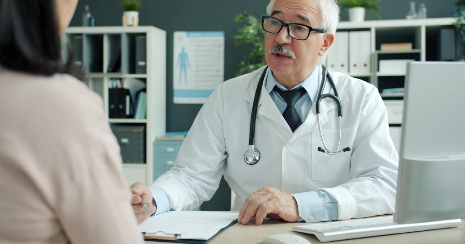 A medical practice reception desk where the phone rings while staff attend to patients.